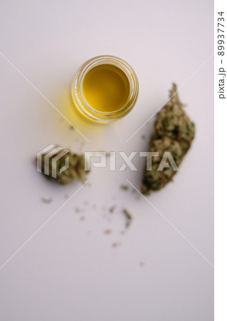 CBD oil with dry cannabis buds in out of focuse zone. Marihuana extract. Flat lay. Minimalism 89937734