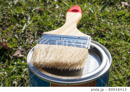 Clean paint brush on closed color can Clean paint brush on closed color can 89938413
