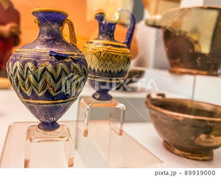 two decorative jugs of blue color with a pattern. nearby are brown clay plates. museum exhibits. decorative dishes of the ancient world two decorative jugs of blue color with a pattern. nearby are brown clay plates. museum exhibits. decorative dishes of the ancient world 89939000