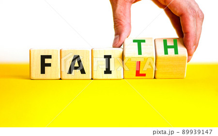 Faith instead fail symbol. Businessman turns wooden cubes and changes the concept word Fail to Faith. Beautiful yellow table white background. Business and faith instead fail concept. Copy space. 89939147