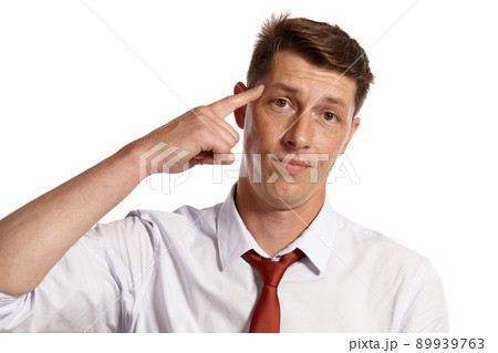 Young man in a classic white shirt and red tie posing isolated on white background. Young man in a classic white shirt and red tie posing isolated on white background. 89939763