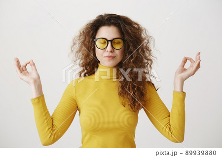 Portrait calm woman smiling doing yoga exercises relaxing on white blank studio wall, happy young girl meditating feeling no stress. 89939880
