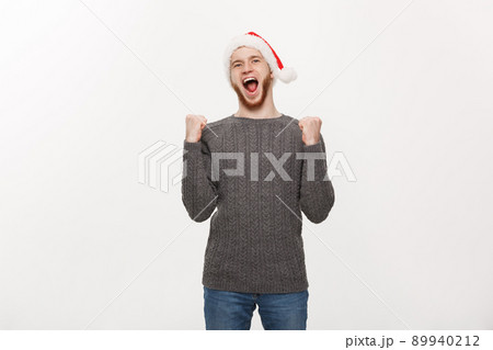Holiday Concept - Young beard man in sweater showing hand up with exciting feeling. Holiday Concept - Young beard man in sweater showing hand up with exciting feeling. 89940212
