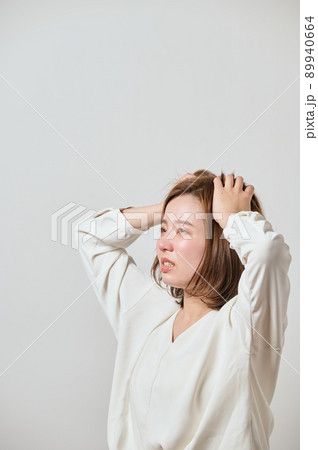両手で頭を抱える若い女性 両手で頭を抱える若い女性 89940664