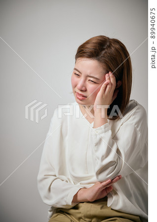 頭痛がして手でこめかみをおさえる若い女性 頭痛がして手でこめかみをおさえる若い女性 89940675