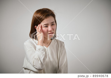 頭痛がして手でこめかみをおさえる若い女性 頭痛がして手でこめかみをおさえる若い女性 89940678