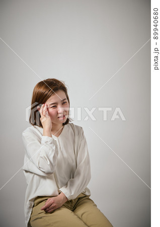 頭痛がして手でこめかみをおさえる若い女性 頭痛がして手でこめかみをおさえる若い女性 89940680