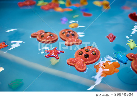 Multicolored plastic toy fish in pool for children's fishing, concept game. Multicolored plastic toy fish in pool for children's fishing, concept game. 89940904