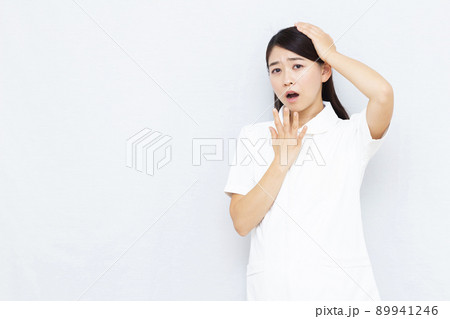 頭を抱えている30代の女性看護師 頭を抱えている30代の女性看護師 89941246