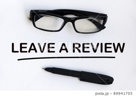 Leave a review text on white cover with pen and glasses background. Feedback and review concept. 89941705