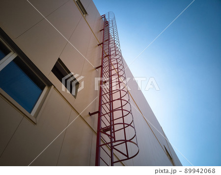 Outdoor fire escape ladder on industrial building wall Outdoor fire escape ladder on industrial building wall 89942068