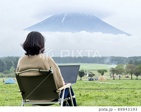 キャンプ場の富士山の前でパソコンを操作する女性のアップ 89943193