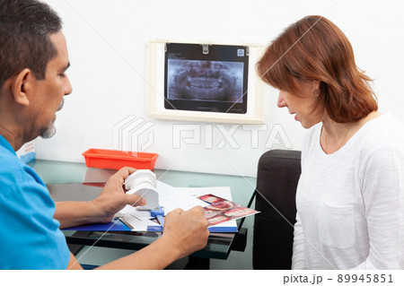 Beautiful woman receiving explanations about her dental treatment with her dentist Beautiful woman receiving explanations about her dental treatment with her dentist 89945851