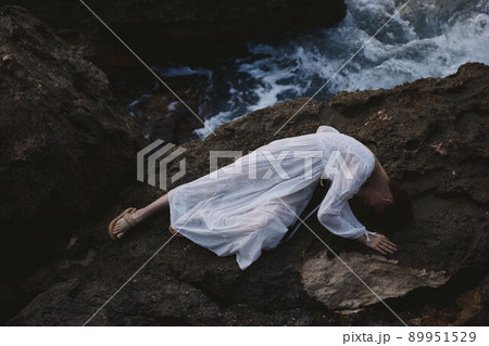sensual woman in a white dress lying on a stone in a white dress Summer vacation concept sensual woman in a white dress lying on a stone in a white dress Summer vacation concept 89951529