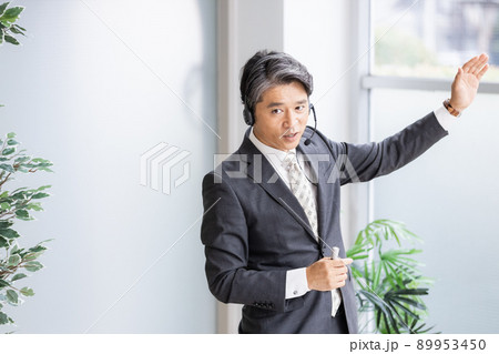 ヘッドセットをつけて人前で話をするビジネスパーソン 89953450