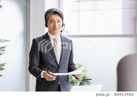 ヘッドセットをつけて人前で話をするビジネスパーソン ヘッドセットをつけて人前で話をするビジネスパーソン 89953460