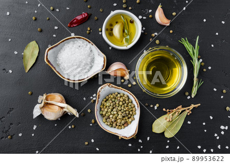 Olive oil, herbs and spices on black background Olive oil, herbs and spices on black background 89953622