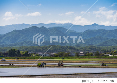 《石川県》加賀市　水田の田植え風景と残雪の白山連峰 89954146