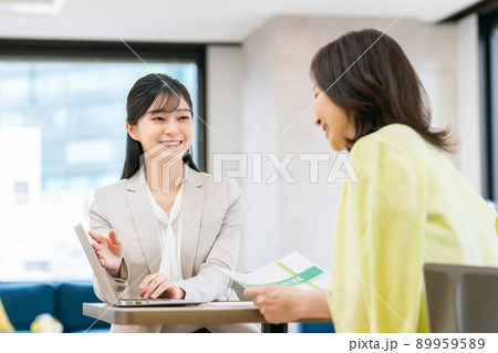 ミドルの女性に説明する若いビジネスウーマン ミドルの女性に説明する若いビジネスウーマン 89959589