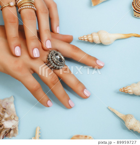 beautiful woman hands with pink manicure holding plate with pearls and sea shells, luxury jewelry concept close up 89959727