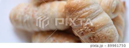 Hot delicious sausages in dough on a plate, puff bun Hot delicious sausages in dough on a plate, puff bun 89961750