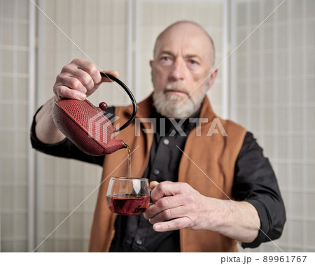 senior man pouring tea into glass 89961767