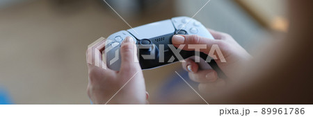 Female hands holding game joystick, close-up 89961786