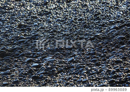 wet dark pebbles and rocks on the ocean coast. black reynisfjara beach in Iceland wet dark pebbles and rocks on the ocean coast. black reynisfjara beach in Iceland 89963089