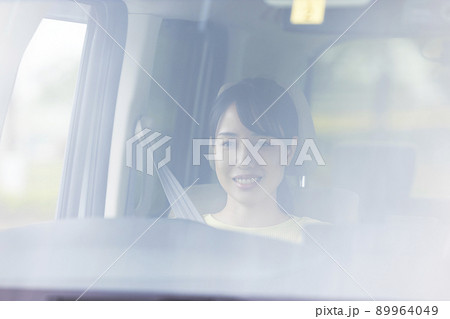 車を運転する若い女性 89964049