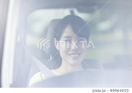 車を運転する若い女性 89964050