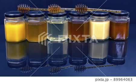 jars with different types and colors of honey on a white blue background. organic vitamin products jars with different types and colors of honey on a white blue background. organic vitamin products 89964063