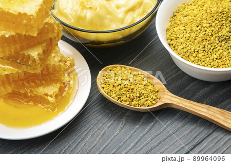 Fresh flower honey of different varieties, pollen and honeycomb with spoons Fresh flower honey of different varieties, pollen and honeycomb with spoons 89964096