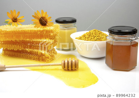 Fresh flower honey in combs and a wooden spoon. vitamin food for health and life Fresh flower honey in combs and a wooden spoon. vitamin food for health and life 89964232