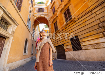 Woman walks on narrow old street in Rome Woman walks on narrow old street in Rome 89965642