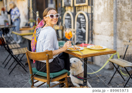 Woman eating italian pasta at restaurant on the street in Rome 89965973