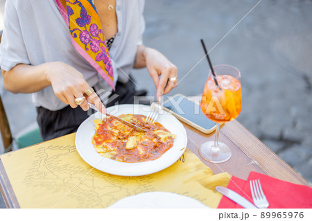 Woman eating ravioli with bolognese sause 89965976