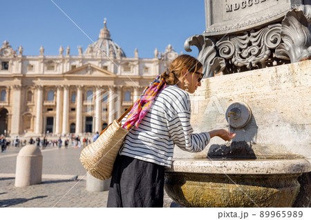 Woman drinks water from fountain on the main square in Vatican Woman drinks water from fountain on the main square in Vatican 89965989
