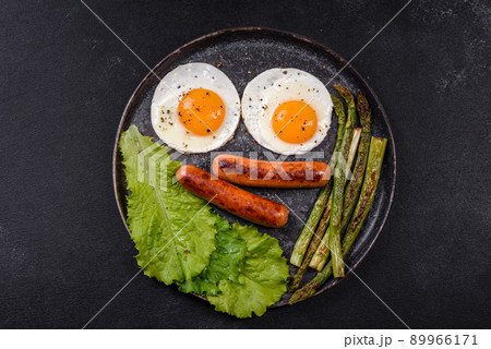 A delicious nourishing breakfast with fried eggs, sausages, asparagus, tomatoes, avocado, spices and herbs A delicious nourishing breakfast with fried eggs, sausages, asparagus, tomatoes, avocado, spices and herbs 89966171