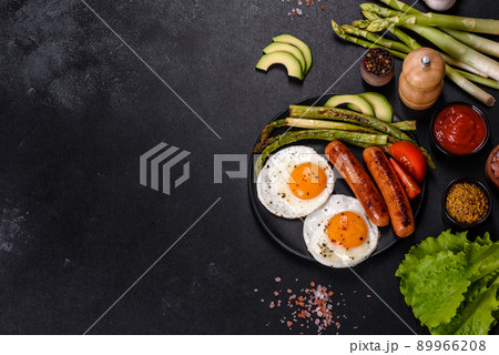 A delicious nourishing breakfast with fried eggs, sausages, asparagus, tomatoes, avocado, spices and herbs A delicious nourishing breakfast with fried eggs, sausages, asparagus, tomatoes, avocado, spices and herbs 89966208