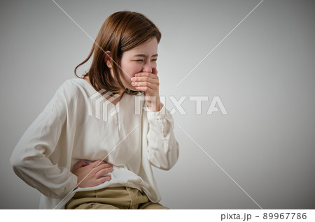 食中毒になり吐き気と腹痛がする若い女性 89967786