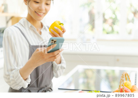 スマホを見る女性　キッチン 89967805