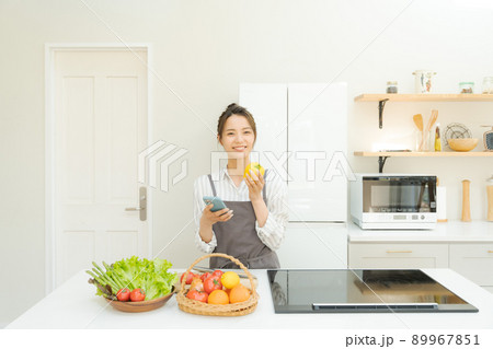 スマホを持つ女性　キッチン 89967851