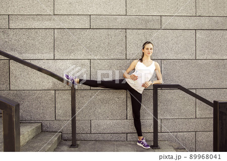 Fitness beautiful woman with freckles on her face drinking water and sweating after exercising in city. Female athlete after work out. looking at camera and smilling. 89968041