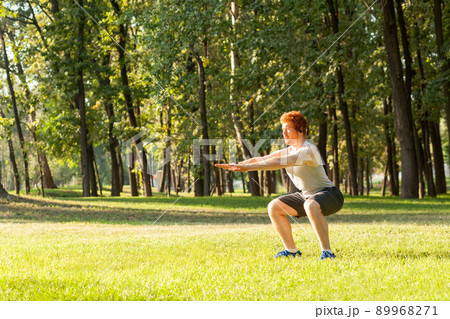 Sit ups. Young adult redhead man having intensive training outdoors in morning 89968271