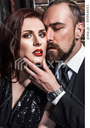 Love and passion concept, closeup. Bearded man kissing redhead sensual woman. Studio shot Love and passion concept, closeup. Bearded man kissing redhead sensual woman. Studio shot 89968601