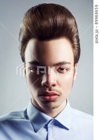 Portrait of young man with retro classic pompadour hairstyle. studio shot. looking at camera. 89968659