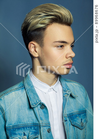 portrait of multiracial handsome man wearing jeans jacket and white shirt on blue wall background. portrait of multiracial handsome man wearing jeans jacket and white shirt on blue wall background. 89968676