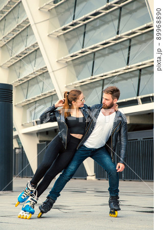 Beautiful roller skater couple with hipster style skating after the rain. 89968890