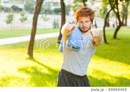Hey you! Fitness model pointig fingers and looking at camera. Outdoor shot 89969469
