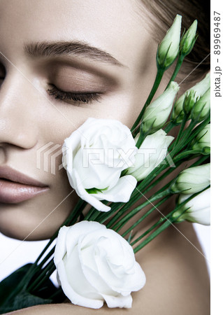 portrait of beautiful model with good skin on white background with white roses flower. portrait of beautiful model with good skin on white background with white roses flower. 89969487